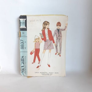 Peut inclure: Un patron de couture vintage McCall's pour séparations de filles, comprenant une veste, une jupe, un pantalon et un haut. La couverture présente des illustrations de filles portant les tenues. Le patron est de taille 8 et porte le numéro "8837".