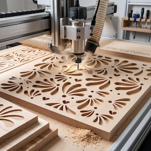 May include: A CNC machine cutting a floral pattern into a light-colored wooden board. The machine is silver and black, with a drill bit actively carving the design. The text "CNC-Cut Pattern" is visible on a separate piece of wood.