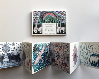 Puede incluir: Una decoración de acordeón de papel con un tema celestial. La decoración presenta un diseño colorido con estrellas, un pájaro y patrones geométricos. El texto "Paper Concertina Decoration" y "Celestial" está impreso en la parte delantera.