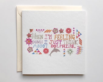 Puede incluir: Una tarjeta blanca con un diseño colorido y el texto "When I'm feeling down I just think about dolphins."