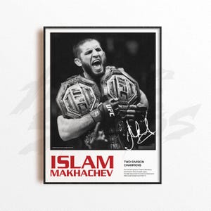 May include: Black and white framed poster featuring Islam Makhachev, a UFC fighter, holding two championship belts. The poster includes the text "ISLAM MAKHACHEV" in red and "TWO-DIVISION CHAMPIONS". A signature is visible on the right side.