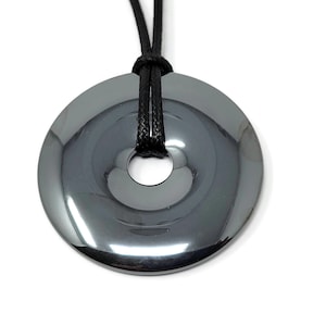 May include: A black hematite pendant in the shape of a donut with a black cord.