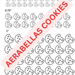 May include: Black and white cookie-shaped stickers in three sizes: 0.5", 0.75", and 1". The stickers have a bite taken out of them and small dot details. The text "AERABELLAS COOKIES" is printed diagonally across the image in red.