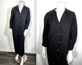 May include: A long black button-down dress with a white polka dot pattern. The dress has a collared neckline and long sleeves.