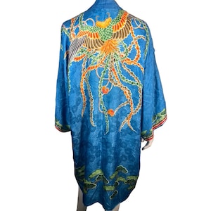 May include: A blue silk robe with a phoenix design in orange, green, and yellow. The robe has a floral pattern and a green and orange trim.