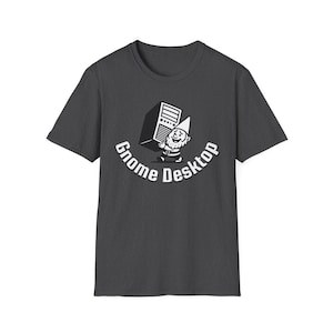Può includere: T-shirt grigio scuro con una grafica in bianco e nero. Il design presenta uno gnomo che tiene un server di computer, con la scritta "Gnome Desktop" a forma di arco. La maglietta è in cotone.