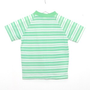 May include: A green and white striped short-sleeved shirt with a mock neck.