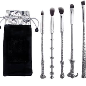 Pu&ograve; includere: Un set di sei pennelli per il trucco con manici argentati ornati e setole nere, insieme a un sacchetto di velluto nero con fodera argentata. Il sacchetto riporta la scritta "Sizzylash cosmetics".