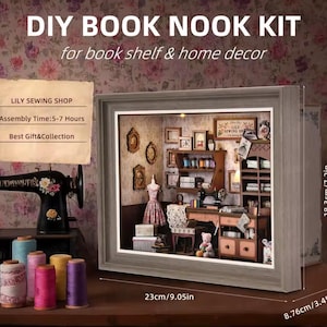 May include: A DIY Book Nook Kit with a miniature sewing shop scene inside a framed display. The frame is 9.05 inches wide and 7.2 inches tall. The kit includes a sewing machine, dress form, and various sewing supplies. The text on the sign says "LILY SEWING SHOP".