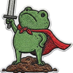 May include: Embroidered patch featuring a green frog wearing a red cape and ascot, holding a silver sword. The frog stands on a brown mound, with the word "Huzzah" in white letters on a black background.