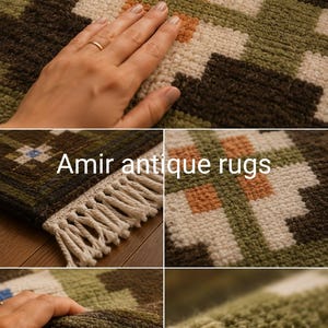 May include: A woven rug featuring a geometric pattern in shades of olive green, dark brown, cream, and orange. The rug has a textured pile and white fringe along the edge. The text Amir antique rugs is visible on the surface of the rug.