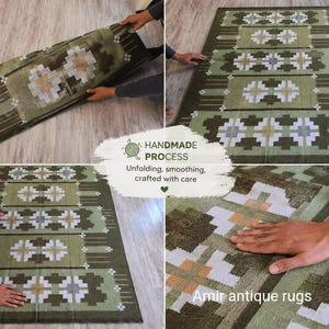 May include: A rectangular area rug featuring a repeating geometric pattern in shades of olive green, white, and light brown. The rug displays a symmetrical design with cross-like motifs. Text on the image reads: HANDMADE PROCESS Unfolding, smoothing, crafted with care, and Amir antique rugs.