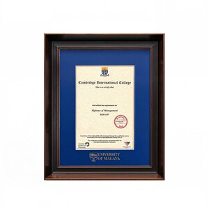Puede incluir: Un diploma enmarcado del Cambridge International College para un Diploma of Management, con un documento color crema con texto negro y un sello rojo, sobre un paspartú azul profundo dentro de un marco de madera marrón oscuro con detalles dorados.