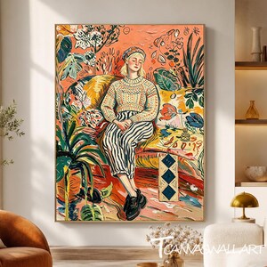 May include: A vertical wall art print featuring a stylized illustration of a person wearing a patterned sweater and striped trousers, seated on a yellow sofa amidst vibrant, colorful foliage and abstract botanical shapes in shades of orange, green, and blue.