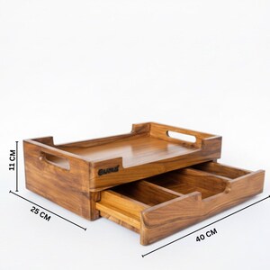 May include: Wooden desk organizer with a pull-out drawer. The organizer is rectangular, with a top tray and a drawer below. The dimensions are 11 cm high, 25 cm wide, and 40 cm long.