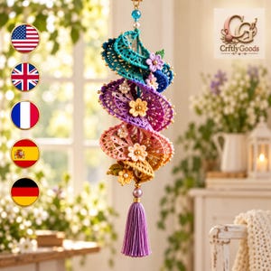 May include: A spiral-shaped hanging ornament crafted from colorful crocheted lace in shades of teal, purple, pink, and yellow. The piece is adorned with small fabric flowers, faux pearls, and gold beads, finished with a lavender tassel at the bottom.