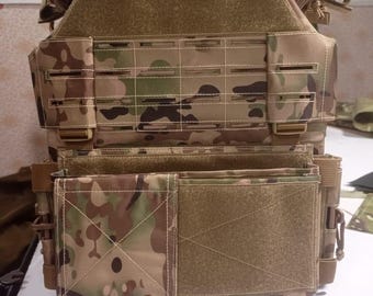 Puede incluir: Un chaleco táctico de camuflaje en tonos marrones, verdes y beige. El chaleco tiene múltiples bolsillos, correas y correas MOLLE para sujetar equipo adicional. La parte delantera tiene un gran panel de velcro y una serie de correas horizontales.