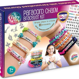 May include: Crafty Witty Paracord Charm Bracelet Kit. The box shows colorful bracelets with personalized charms. The kit includes rub-on transfer sheets and charms. The image features bracelets with the words "Believe", "Lindsey", and "Just Smile".