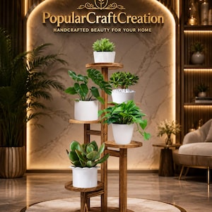 May include: A multi-tiered wooden plant stand with a central vertical support and five circular shelves. Each shelf holds a white cylindrical pot containing a green houseplant. The text PopularCraftCreation Handcrafted Beauty For Your Home is visible.
