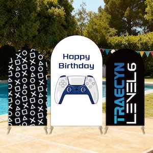 May include: Three arched backdrop covers for events. The left is black with white geometric shapes. The center is white with a blue game controller graphic and the text Happy Birthday. The right is black with the blue and white text TRAECYN LEVEL 6.