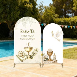 Puede incluir: Dos fundas de fondo arqueadas para una Primera Comunión. La más grande presenta el texto 'Russell's FIRST HOLY COMMUNION' con un cáliz dorado, una vela y un libro. La más pequeña muestra una paloma blanca, un cáliz y una vela.