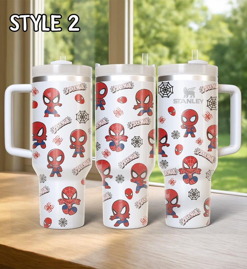 May include: Three white insulated tumblers with a Spider-Man design. Each tumbler features a repeating pattern of Spider-Man illustrations, spiderwebs, and the word "Spider-Man". The tumblers have white handles and lids.
