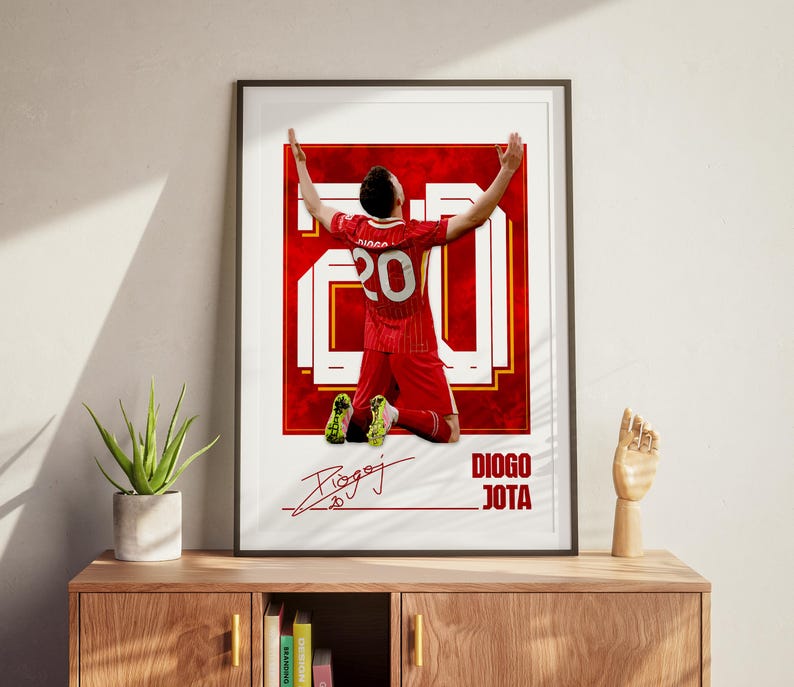 Pode incluir: P&ocirc;ster emoldurado com um jogador de futebol em uniforme vermelho, n&uacute;mero 20, ajoelhado com os bra&ccedil;os levantados. O p&ocirc;ster inclui a assinatura do jogador e o nome "DIOGO JOTA" em texto branco sobre fundo vermelho.