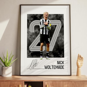 Puede incluir: Póster enmarcado con un futbolista con camiseta a rayas blancas y negras y pantalones cortos negros. El número 27 se muestra detrás del jugador, con el nombre "NICK WOLTEMADE" debajo. El fondo tiene un diseño abstracto y ahumado.