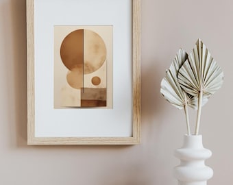 May include: A framed abstract art print featuring geometric shapes in shades of brown and beige. The artwork is displayed in a light wood frame with a white mat. A white vase with dried palm leaves is next to the framed art.