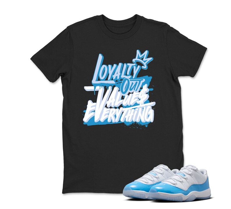 Peut inclure: T-shirt noir avec le texte "Loyalty Over Values Everything" en blanc et bleu clair. Une paire de baskets bleu clair et blanches est au premier plan.