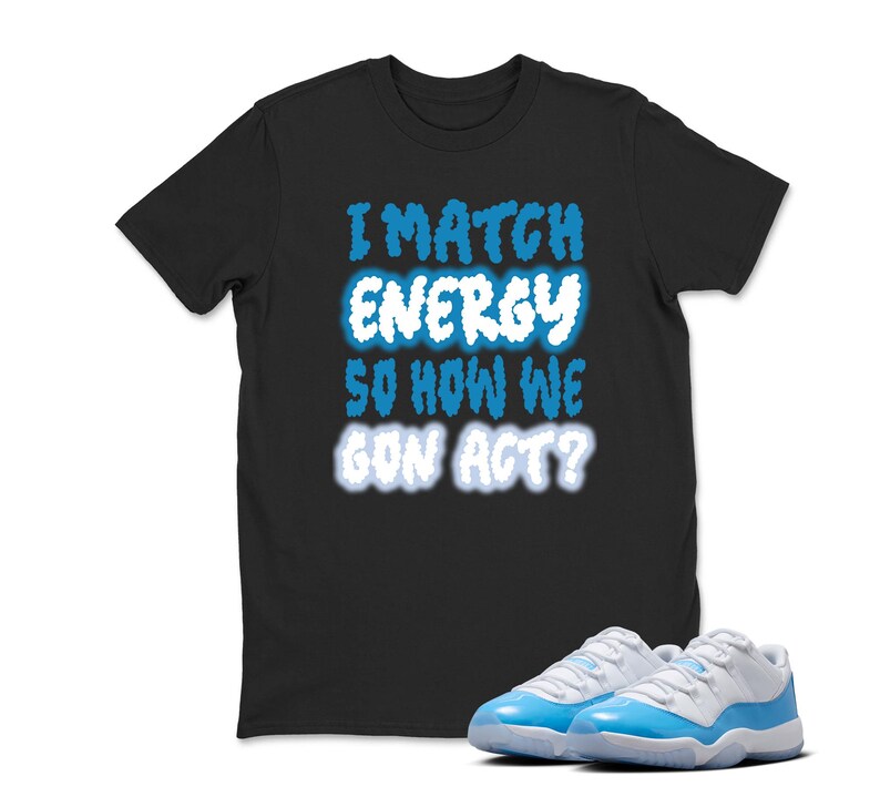 May include: Black t-shirt with the text "I MATCH ENERGY SO HOW WE GON ACT?" in blue and white. A pair of light blue and white sneakers are in front of the shirt.