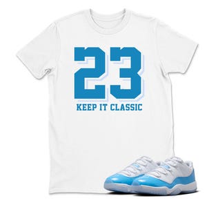 Puede incluir: Camiseta blanca con el n&uacute;mero 23 en azul y el texto "KEEP IT CLASSIC". Un par de zapatillas azules y blancas est&aacute;n en la parte inferior de la imagen.