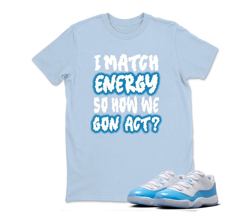 May include: Light blue t-shirt with the text "I MATCH ENERGY SO HOW WE GON ACT?" in white and blue. A pair of light blue and white sneakers are in the foreground.