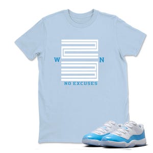 May include: A pale blue t-shirt featuring a white graphic design and the text "WON" and "NO EXCUSES". A pair of light blue and white trainers are in the foreground.