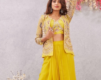 May include: A bright yellow three-piece outfit, comprising a crop top, a high-waisted skirt, and a jacket with detailed embroidery. The jacket has long sleeves and a decorative design. The skirt has a draped front. The outfit is a vibrant yellow colour.