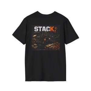 May include: A black short-sleeve t-shirt featuring a graphic print of a cat in a suit sitting at a desk with stacks of cash and gold bars. The text STACK. is printed in large white letters above the cat, with additional small text details.