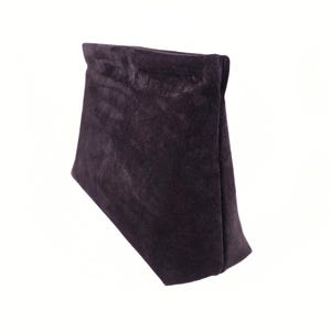 Könnte beinhalten: Ein dunkelvioletter Samtbeutel, gefaltet und aufrecht vor weißem Hintergrund. Der Beutel hat ein weiches, strukturiertes Aussehen mit subtilen Falten und Schatten, die seine Form hervorheben. Das Gesamtdesign ist schlicht und elegant.