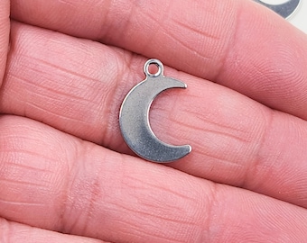 May include: A silver crescent moon charm pendant. The charm is made of metal and has a smooth, polished finish.