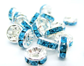 May include: A group of silver-toned bead caps with a single row of light blue rhinestones around the edge.