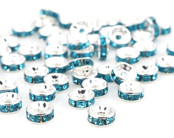May include: A scattering of silver-toned bead caps with a row of turquoise rhinestones around the edge.