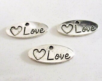 May include: Three silver oval-shaped charms with a heart and the word "Love" engraved on each.