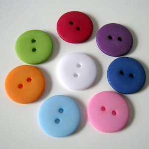 Peut inclure: Assortiment de huit boutons à deux trous de différentes couleurs, dont rouge, vert, violet, blanc, bleu, orange, bleu clair et rose.