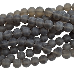 May include: A strand of grey frosted glass beads. The beads are round and have a matte finish.