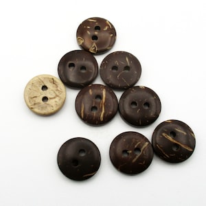 May include: A collection of brown and natural coconut shell buttons with two holes each. The buttons are arranged in a triangular shape.