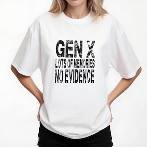 May include: White t-shirt with the text "GEN X LOTS OF MEMORIES NO EVIDENCE" in a distressed black font. The shirt is a crew neck and has short sleeves. The model is wearing black pants.
