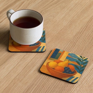 May include: Two square coasters with a fruit bowl design. One coaster has a white mug with tea on top. The coasters feature a bowl of fruit including lemons, oranges, grapes, and a pear. The background has blue and yellow geometric shapes.