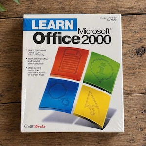 以下が含まれることがあります： Windows 98/95 CD-ROM用Learn Microsoft Office 2000の白いソフトウェアボックス。カバーには青と黒のテキストでタイトルが記載されており、赤、緑、青、黄色の4つのカラフルな正方形のアイコンにピクセル化されたグラフィックが表示されています。