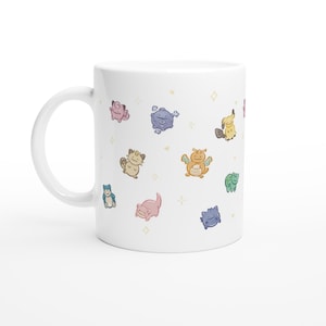 May include: A white ceramic mug featuring a repeating pattern of small, colorful, stylized cartoon creatures in pastel tones. The design includes various fictional characters with simple, rounded features scattered across the surface, accented by tiny yellow stars.