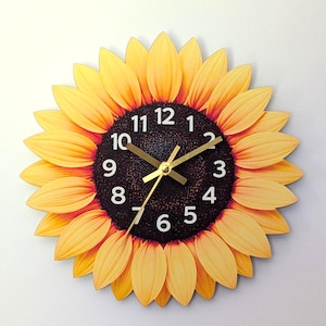 May include: A round wall clock shaped like a sunflower with yellow petals surrounding a dark brown centre. The clock face features white Arabic numerals from 1 to 12 and three gold-coloured hands indicating the time against the textured dark background.