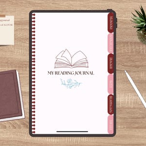 May include: A digital reading journal with a white interior and a dark brown border, featuring tabs for 'My Books', 'Tracker', 'Reading Log', and 'Wishlist'. The cover displays the text 'My Reading Journal' and a floral design. A small notebook and a pen are also present.